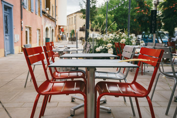 Fototapeta na wymiar Theme cafes and restaurants. Exterior summer terrace of bright colors of street cafe shop in Europe in France. Preserved tables Without people, at tables nobody