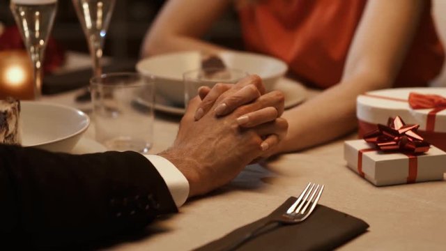 Romantic couple dining together and holding hands