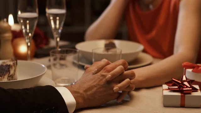 Romantic couple dining together and holding hands