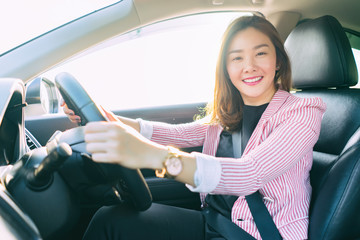 Drive a car with confident and beautiful Smiling Asian women. Rear view of attractive young girl in casual wear looking  at camera,Right hand wheel, driving a cars concept