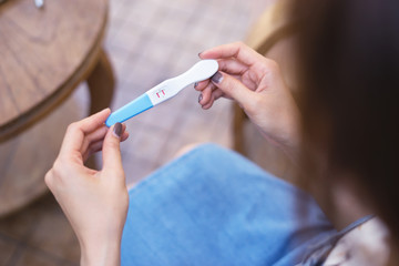pregnancy, fertility, maternity and family concept - happy smiling Asian woman Delighted and surprised,she holding pregnancy test at home look at it