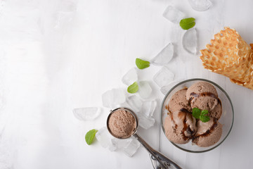 Chocolate ice cream with mint and waffle cone, and a spoon for ice cream. A top view, and with an empty space for an inscription