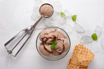 Chocolate ice cream with mint and waffle cone, and a spoon for ice cream.