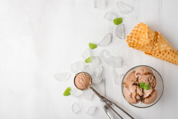 Chocolate ice cream with mint and waffle cone, and a spoon for ice cream. A top view, and with an empty space for an inscription