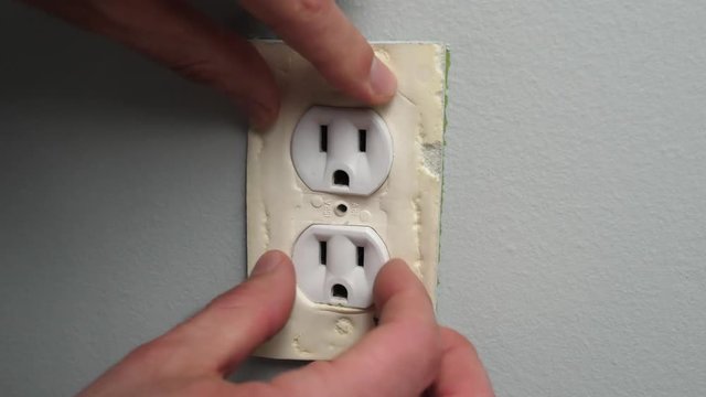 Insulating an electrical outlet to prevent air drafts and loosing heat. Making the house more energy efficient.