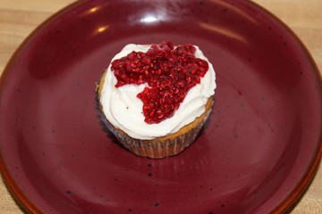 Top of Vanilla Raspberry Cupcake on a red plate