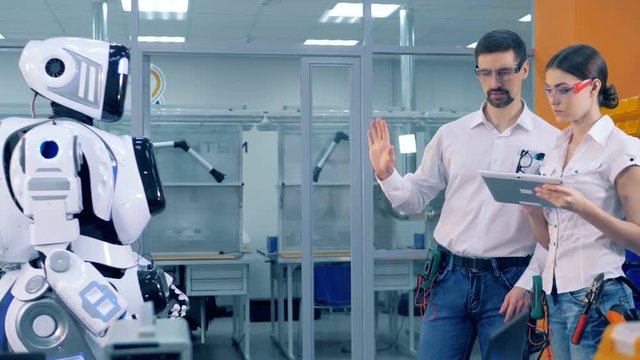 A human-like cyborg is being remotely controlled and is given a drill