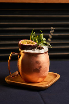 Spicy Mule cocktail on bar table. Alcoholic beverage drink with Rum angostura, reserve rum, dry orange passionfruit ,pure, pineapple pure, spice syrup ingredients, close-up