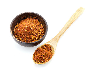 Red pepper flakes in wooden spoon on white background