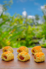 Closeup of a pineapple tart outdoors in a garden with blue sky as background
