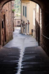 medieval narrow sreet in asciano, Italy