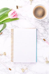 Pink tulips with festive stationary and coffee on white marble background. Feminine job, gender equality, home office and career concept. Copy space