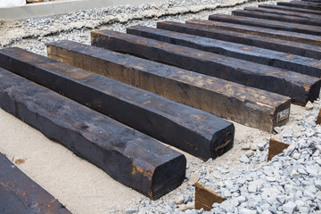 New rails and wooden sleepers are prepared for laying on gravel
