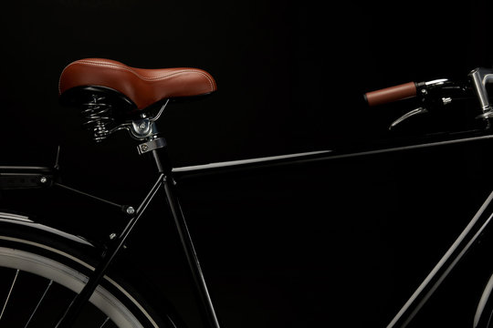 close-up view of saddle and handlebar of classic bicycle isolated on black