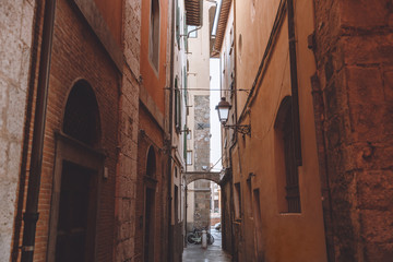 narrow alley between buildings in old city, Pisa, Italy