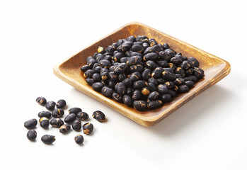 Fototapeta na wymiar black beans in dark wooden bowl isolated on white.