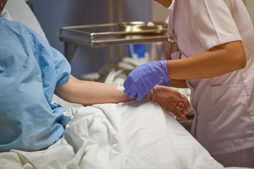 Nurse injecting catheter in hand