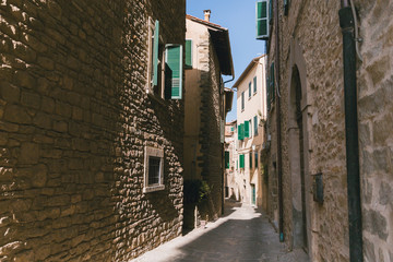 Fototapeta premium urban scene with narrow street and architecture of Tuscany, Italy