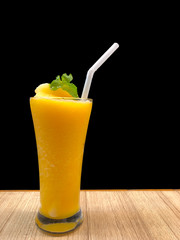 Orange juice in long glass with black background