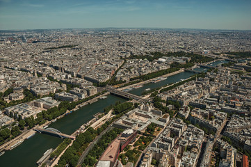 Skyline, Seine River and buildings with sunny blue sky, seen from the Eiffel Tower top in Paris. Known as the “City of Light”, is one of the most impressive world’s cultural center. Northern France.