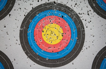Closed up many arrow holes on yellow, blue, and red target.