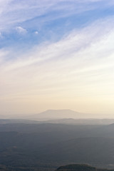 Mountain silhouette above the clouds at sunrise, view from the top view of mountains.