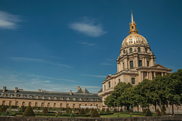 Fototapeta na wymiar Trees in the gardens of Les Invalides Palace with the golden dome in a sunny day at Paris. Known as the “City of Light”, is one of the most impressive world’s cultural center. Northern France.