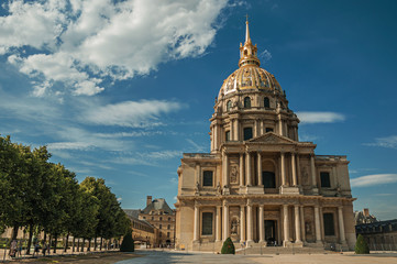 Trees and Front facade of Les Invalides Palace with the golden dome in a sunny day at Paris. Known as the “City of Light”, is one of the most impressive world’s cultural center. Northern France.