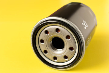 New car oil filter isolated on yellow background