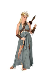 full length portrait of pretty blonde lady wearing fantasy toga gown,  and holding a bow and arrow. standing pose on white background.