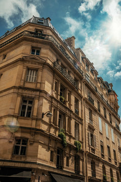 Facade of old typical building with balconies, windows and sunny day in Paris. Known as the “City of Light”, is one of the most impressive world’s cultural center. Northern France. Retouched photo