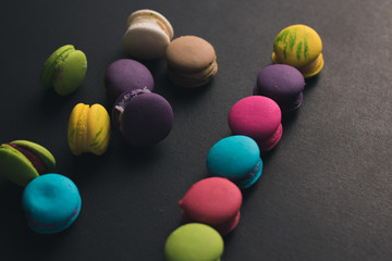 Macaroons on dark background, colorful french cookies macaroons.