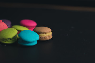 Macaroons on dark background, colorful french cookies macaroons.