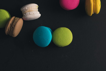 Macaroons on dark background, colorful french cookies macaroons.
