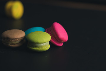 Macaroons on dark background, colorful french cookies macaroons.