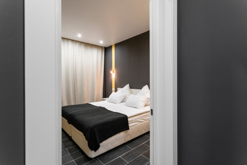 Fototapeta na wymiar Hotel standart room. modern bedroom with white pillows. simple and stylish interior. interior lighting