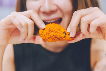 Girl Eating delicious tasty fried chicken wing