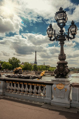 Fototapeta na wymiar Golden statue and lighting post adorning the Alexandre III bridge over the Seine River and Eiffel Tower in Paris. Known as one of the most impressive world’s cultural center. Retouched photo.