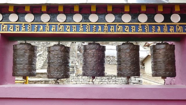 Buddhist prayer wheels with basic mantras in Sanskrit at the entrance to the Tengboche monastery, Solu Khumbu valley, Nepal.