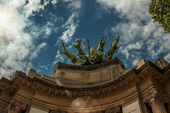 Bronze statue adorning the Grand Palais building top in a sunny day at Paris. Known as the “City of Light”, is one of the most impressive world’s cultural center. Northern France. Retouched photo.