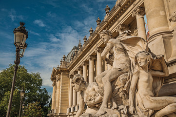 Fototapeta premium Close-up of sculptures decorating the entrance gate of the Petit Palais on sunny day in Paris. Known as the “City of Light”, is one of the most impressive world’s cultural center. Northern France.