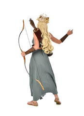 Obraz premium full length portrait of pretty blonde lady wearing fantasy toga gown, and holding a bow and arrow. standing pose on white background.