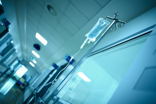 Hospital Building Corridor With Intravenous Drip Bag On The Steel Pole, Medical Background