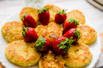 Tasty cheesecakes with fresh strawberries on a white plate