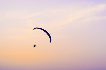 A paraglider flying at sunset sky background, active rest outdoors, extreme sports, extreme sport