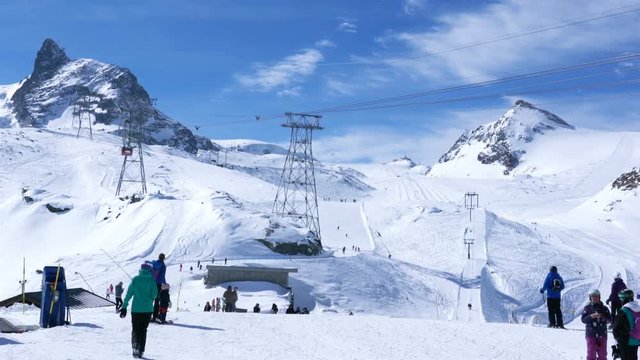Skiers skiing at the ski track on the Klein Matterhorn ski resort in sunny day at Zermatt Village in Switzerland