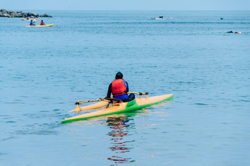 Naklejka premium One girls at sea kayaks or canoe at tropical beach.
