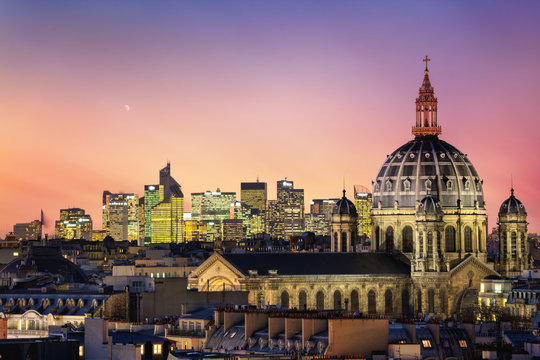 The Saint Augustin church and parisian houses with modern skyscrapers of business La Defense district in the background, France