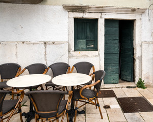 Empty tables of a cafeteria, open door in Cres