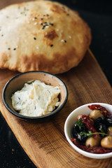 Homemade fresh bread and hummus on wooden board